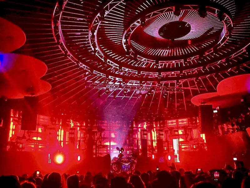 deadmau5 show: a huge circular light rig glowing red above the crowd, the mouse head small at center stage
